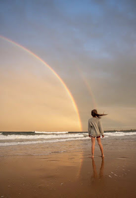 Girl Facing a Sea with a Rainbow in the Sky