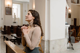 Woman praying for answers in a pew