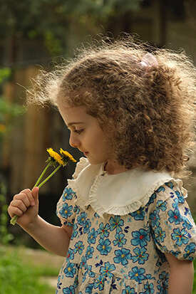 Young girl smelling flowers