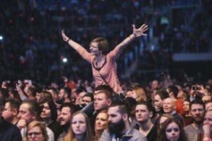 woman with arms outstretched in crowd